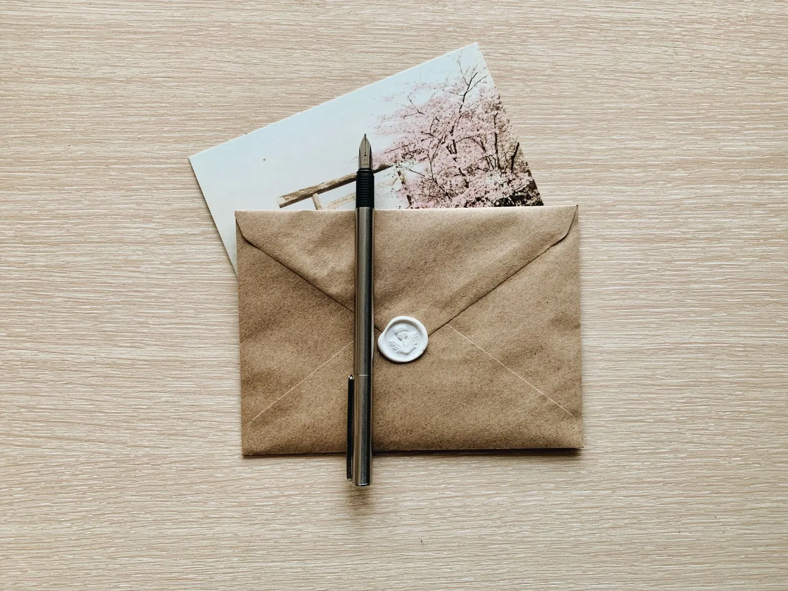 A kraft paper envelope with a pen on a wooden table