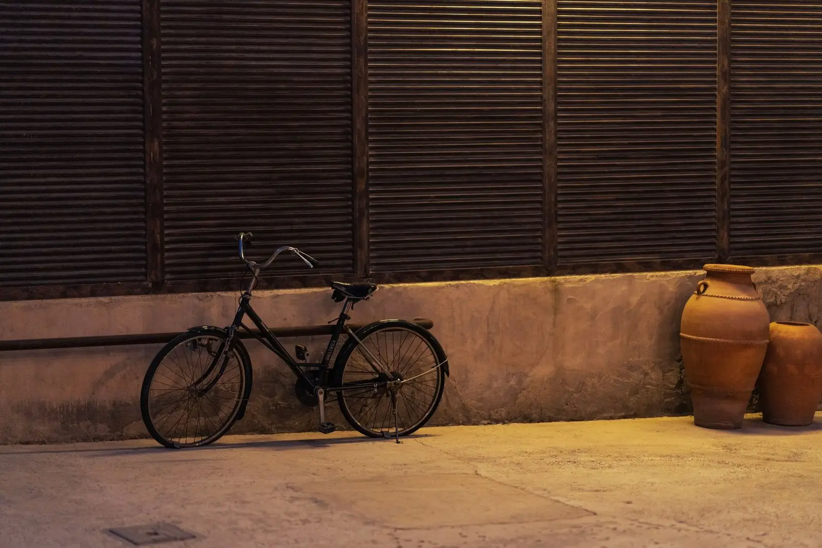Bicycle leaning on a wall in a quiet lane at dusk