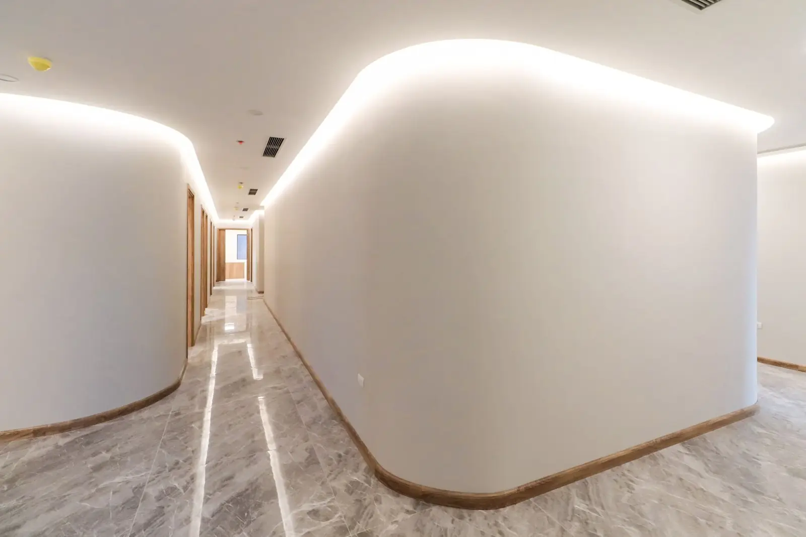 Curved white corridor with a marble floor