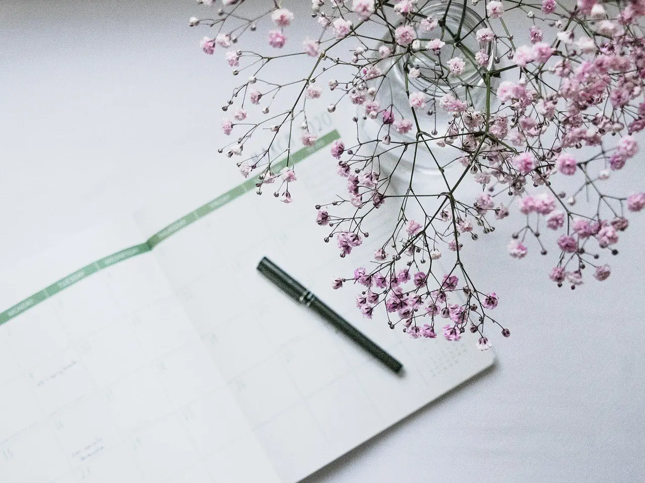 Planner open on a table with a pen